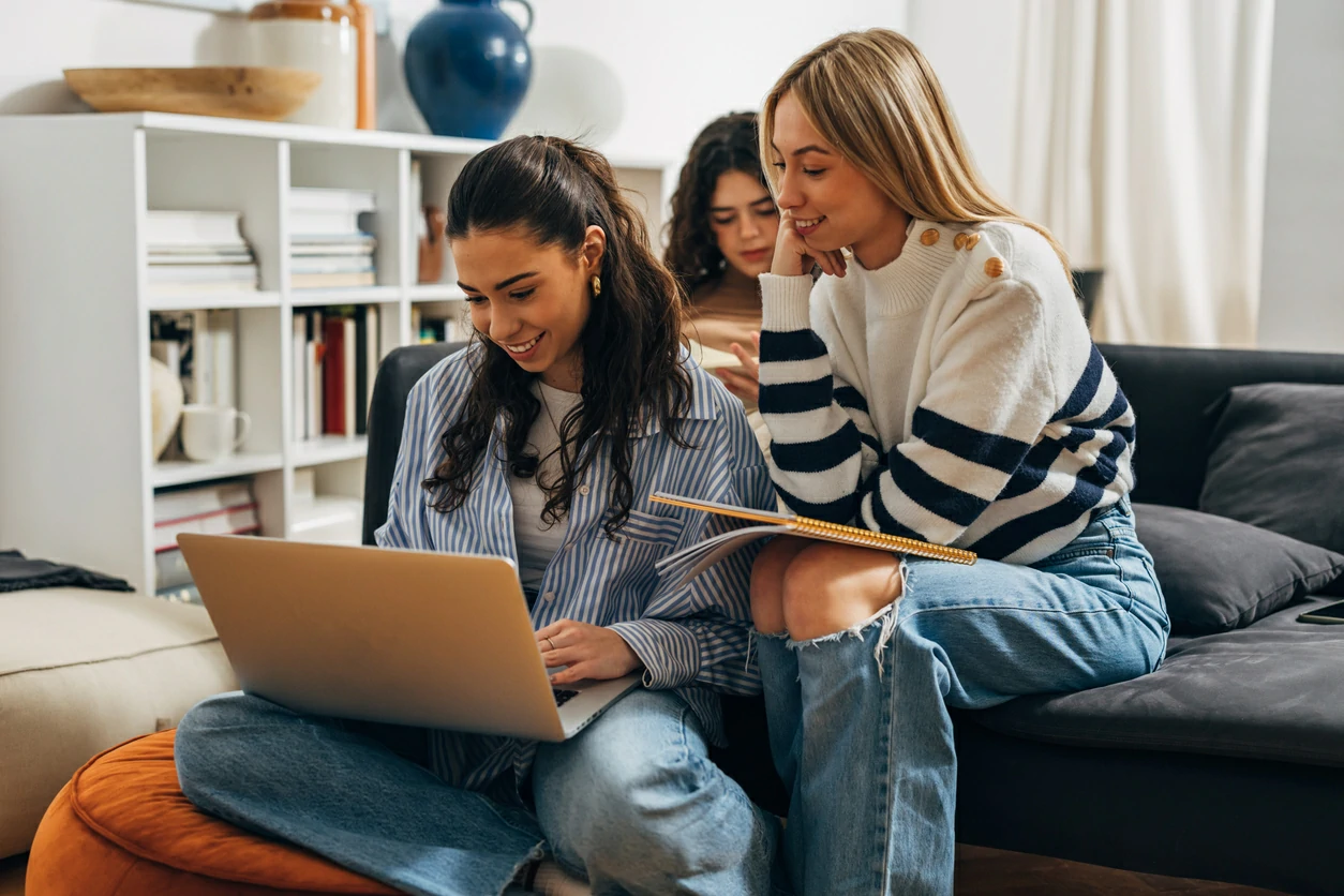 Trois jeunes femmes regardant un ordinateur portable.