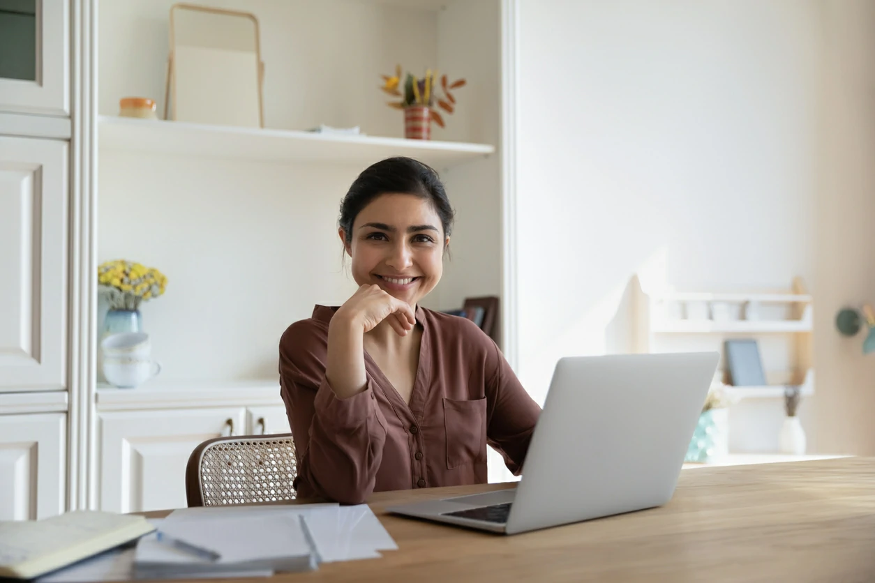 Femme devant des documents et un ordinateur portable