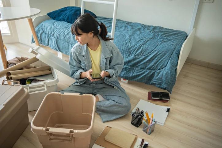 Jeune femme qui fait du rangement dans sa chambre