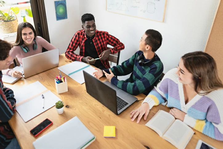 Plusieurs étudiants en train de discuter autour d'une table