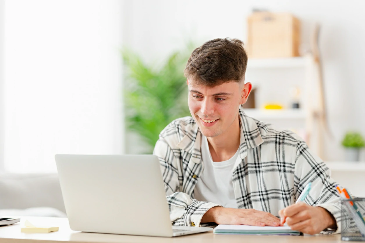 Jeune homme faisant des recherches avec un ordinateur portable.