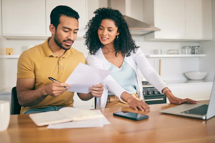 Un homme et une femme consultant des documents sur un bureau
