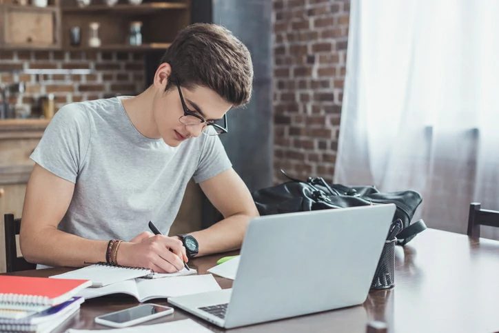 Jeune homme concentré consultant des documents.