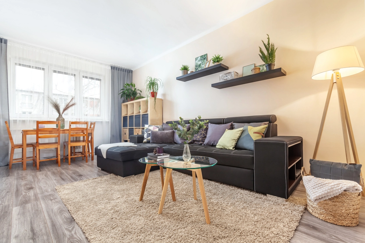 Chambre avec un canapé moderne, une table à manger et d'autre mobiliers.