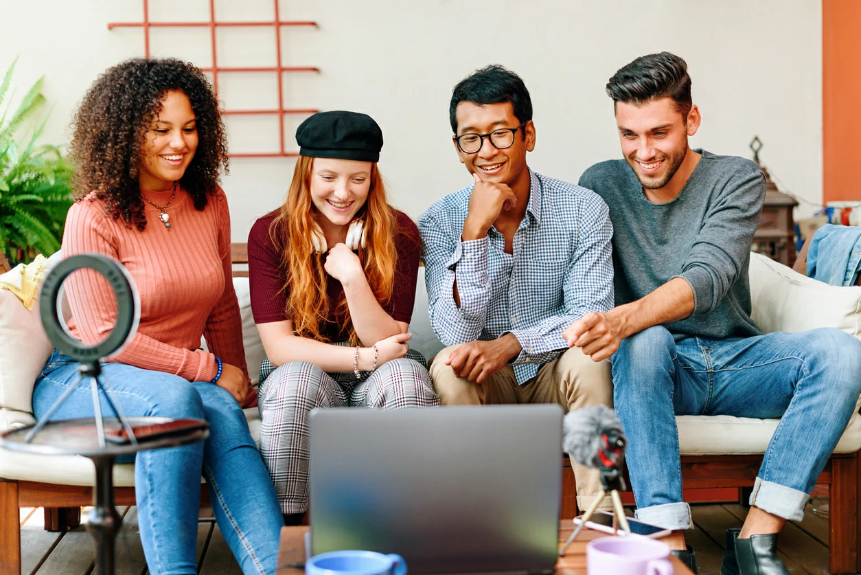 4 étudiants regardant un ordinateur portable.