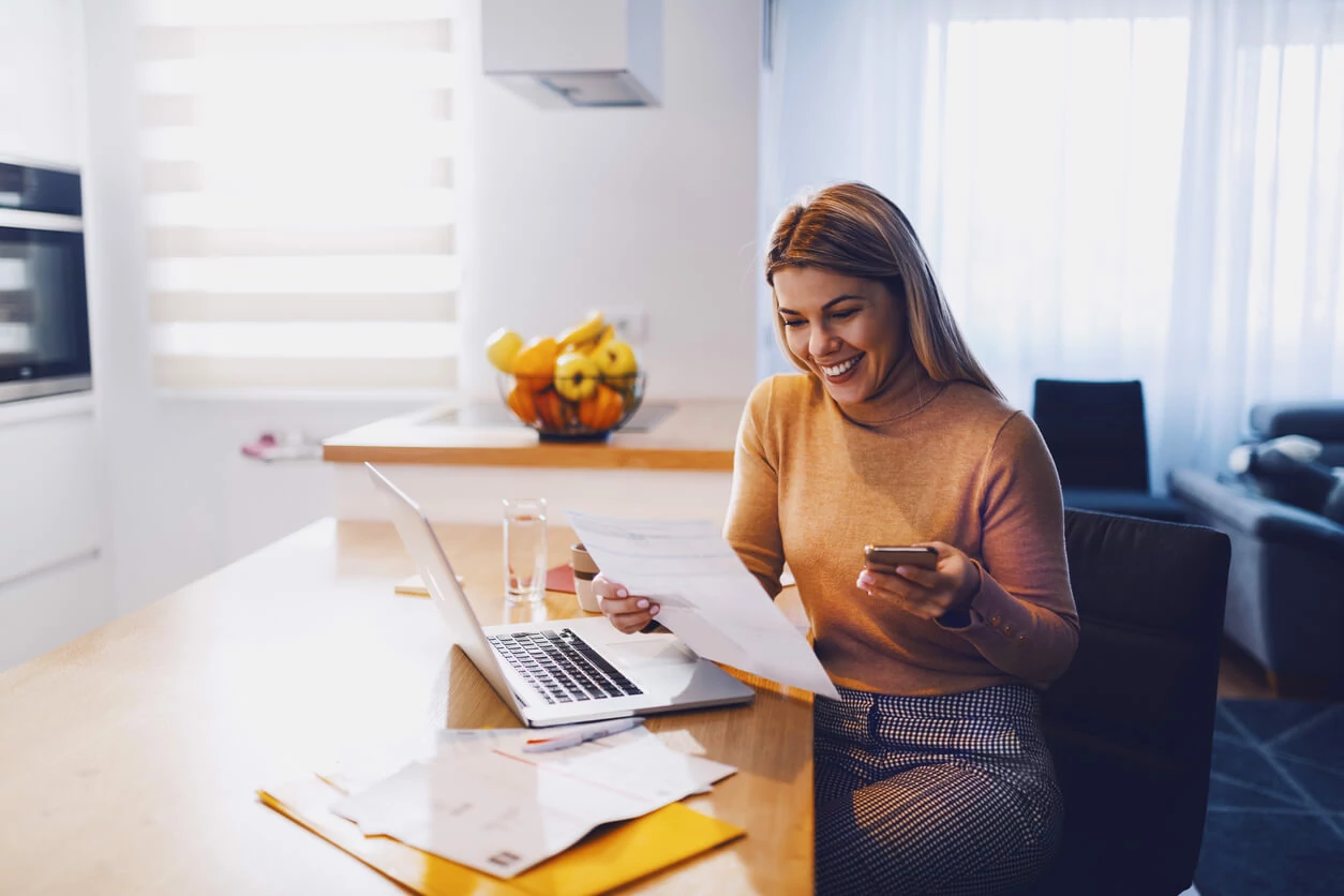 Etudiante qui consulte des dossiers à côté d'un ordinateur portable.