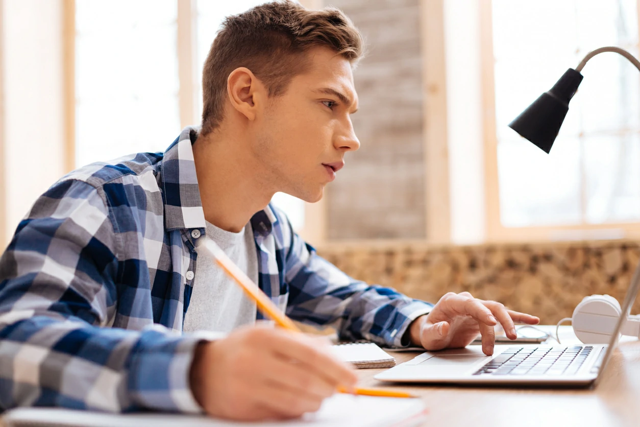 étudiant concentré devant un ordinateur portable